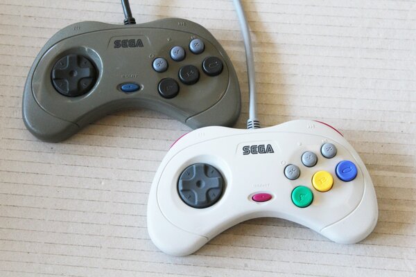 Mandos de Sega Saturn gris y blanco, ambos modelo japonés HSS-0101